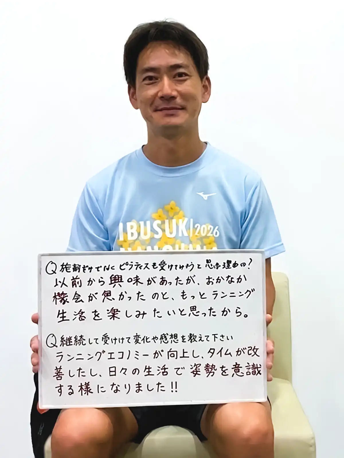 感想を書いたホワイトボードを手に持つ男性患者