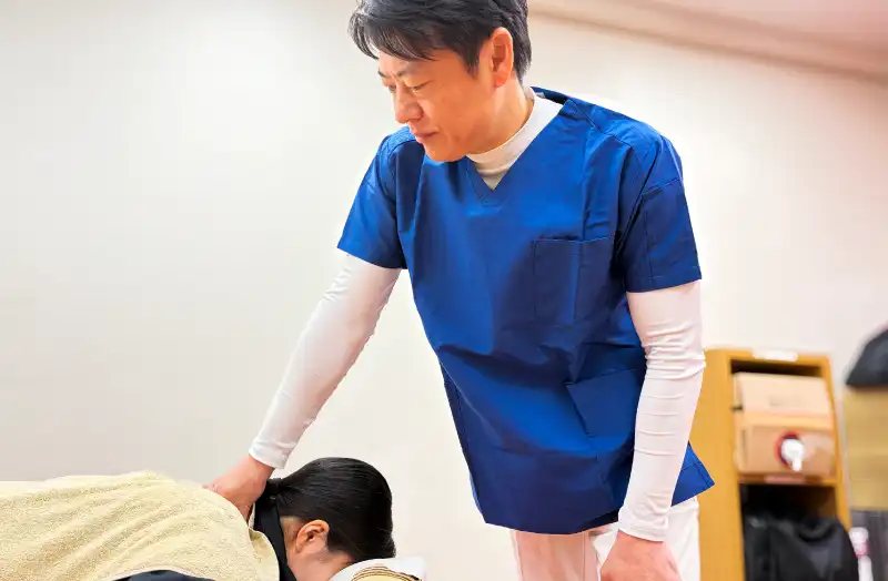 宮下先生が患者の首周りを施術している写真