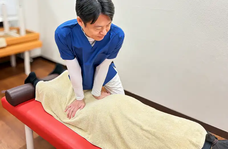 宮下先生が患者の足回りを施術している写真